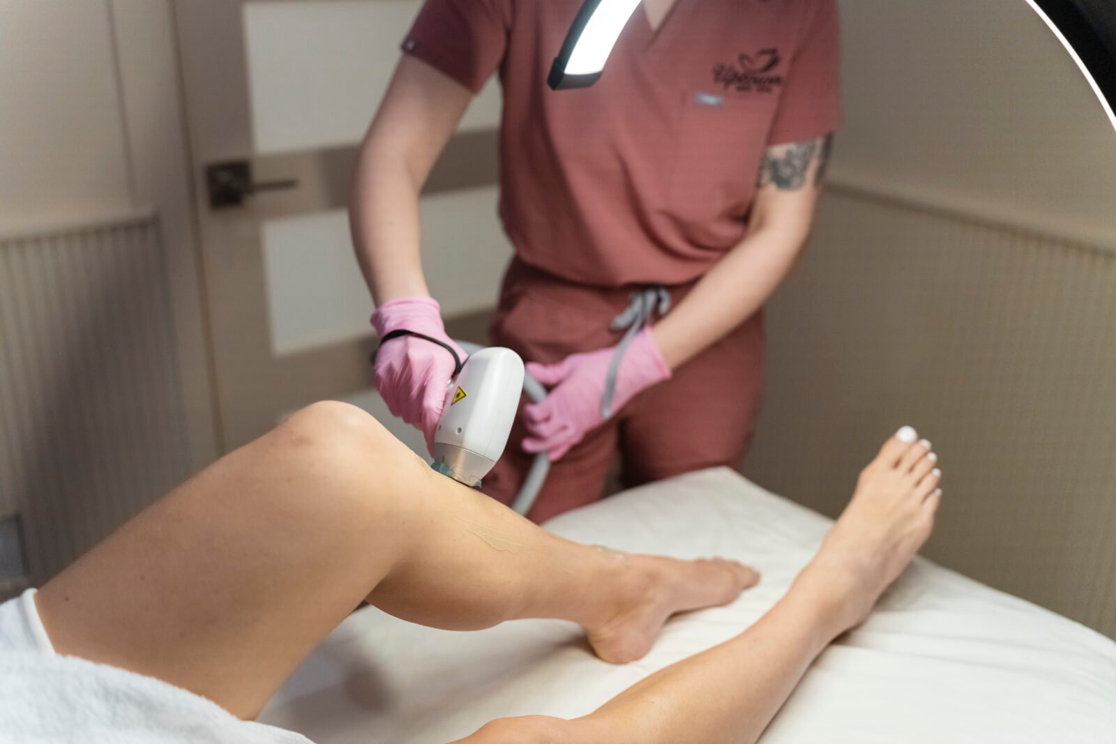 Technician using laser device on client’s lower legs